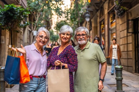 Happy senior friends smiling together on a bright european city street, enjoying a leisurely day of