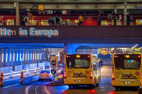 The main train station in Essen, blue illuminated underpass, bus station, am Europaplatz, train on