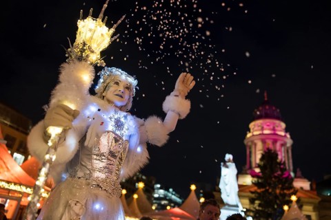 A Black-winged Stilt walker throws confetti at the Christmas market WeihnachtsZauber Gendarmenmarkt