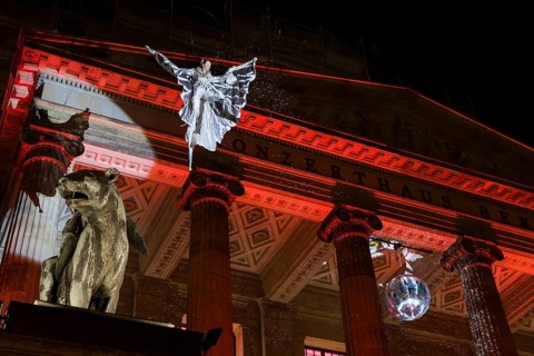 An artist hovers on a crane in front of the concert hall at the Christmas market WeihnachtsZauber