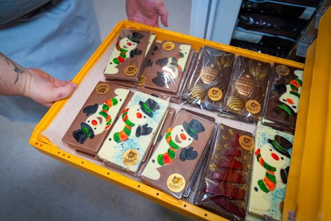 Colourful chocolate bars with snowman motifs in a gift box on the sales shelf, Christmas baking,