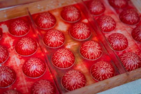 Close-up of red balls with white structures in a mold, Christmas baking, Haselstaller Hof,