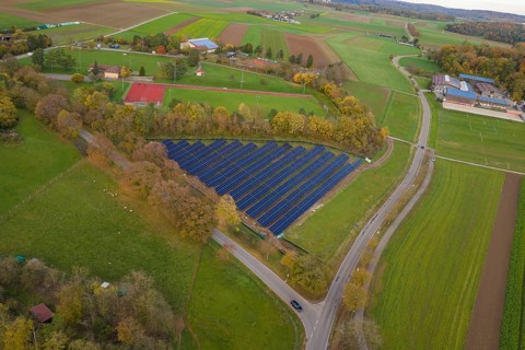 Solar system nestled in a green landscape with roads and fields in autumn, construction of PV