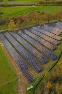 Close view of solar panels in a field with adjacent trees, Bau PV Freifaechenanlage, Weil der