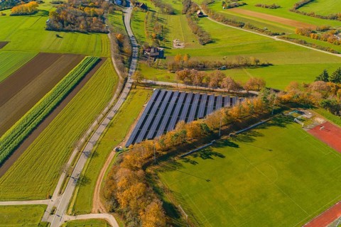 Landscape with solar panels and autumn trees surrounded by roads and fields, PV Freifaechenanlage