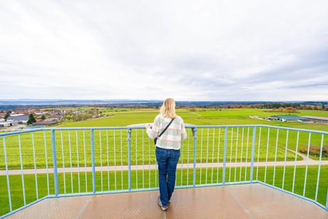 Woman standing on platform looking out over the vast landscape, DÃ¼rrenmettstetten observation