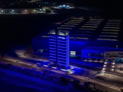Night view of a factory with a blue illuminated tower and modern buildings, Nagold, Calw district,