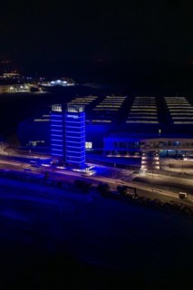 Night view of a factory with a blue illuminated tower in dark surroundings, Nagold, Calw district,