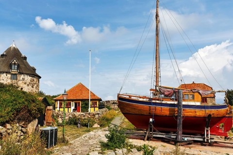 Traditional wooden boat on slipway, small tower, Lille Tarn, round tower with museum,