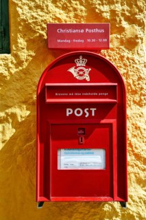 Post office, faÃ§ade detail, red mailbox with post horn and crown, yellow wall, ChristiansÃ¸,