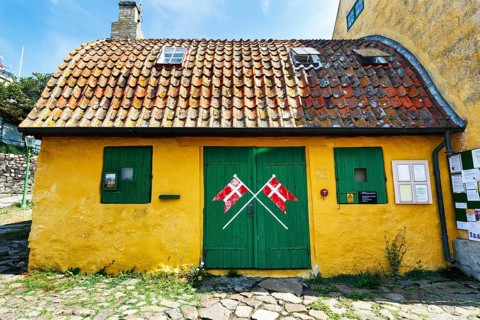 ChristiansÃ¸ Skole, smallest school in Denmark, curved tile roof, characteristic yellow and green,