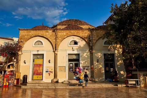 Old town of Nauplion, historic building with round dome and decorated doors, surrounded by trees,