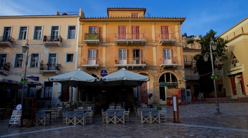 Old town of Nauplion, empty café area in front of historic faÃ§ade in sunny weather in a square,