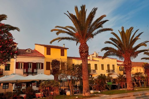 Old town of Nauplion, Mediterranean houses with palm trees in front of them in evening sunlight,