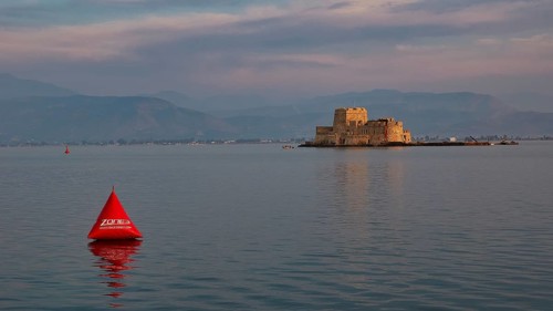 Bourtzi island fortress, historic castle in the evening light on the water with a red buoy,