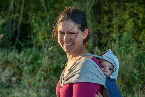 Young mother carrying her baby in a shawl on her back, Othenstorf, Mecklenburg-Western Pomerania,