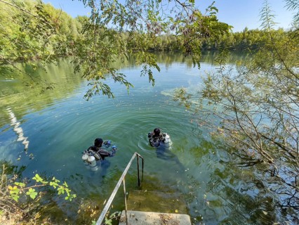 Recreational divers with diving equipment Diving tanks swim near the shore on the water surface of