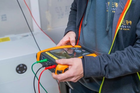 Technician carries out diagnostics for solar system with measuring device device