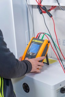 Technician uses measurement device to install solar system