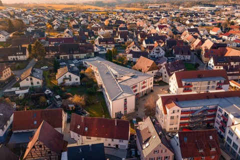 Aerial view of a village with many residential buildings and a community building, Althengstett,