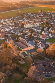 Residential area with many houses and trees seen from above in autumn sunlight, Althengstett, Calw