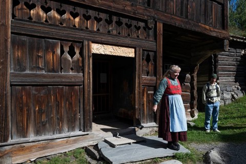 Tourist guide in traditional traditional costume and visitor, BjÃ¸rnstad, farm from VÃ¥gÃ¥,