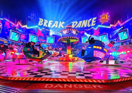 People in the colorful illuminated break dance ride at night at the All Saints Fair, Soest, North