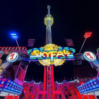 Colourfully illuminated Skyfal free fall tower at night at the All Saints Fair, Soest, North