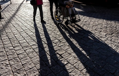Shadows of people on the ground, low sun, winter, silhouettes, elderly person in wheelchair,
