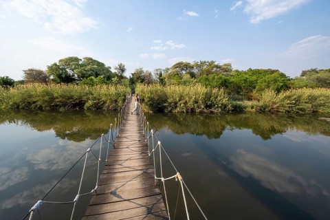 Toruist on the Kavango River, suspension bridge at Camp Kwando, Zambezi region, Caprivi Strip,