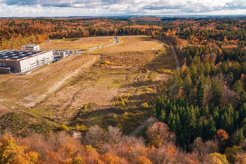 Industrial plant in autumn, surrounded by diverse forest in an open landscape, new Lindenrain