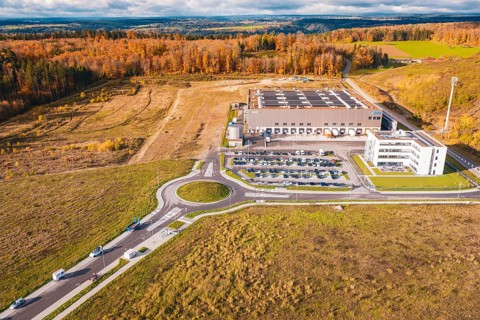 Industrial complex with roundabout, surrounded by forest and empty fields in an autumn environment,