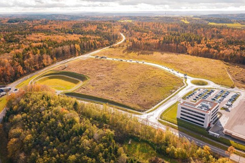 Industrial site with parking lot and adjacent forest in an autumn setting, new Lindenrain