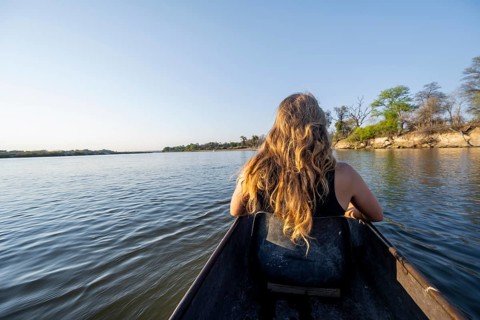 Tourists in a Mokoro, dugout boat on the Okavango River, Caprivi Strip, Namibia