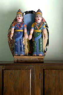 Two painted wooden female figures in traditional South Indian clothing, sari, standing on a closet,