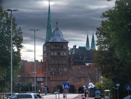 Burgtor, tower of the historic Castel Gate in brick architecture, church towers in the back,