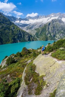 Female mountaineer in front of picturesque mountain landscape, turquoise-blue mountain lake