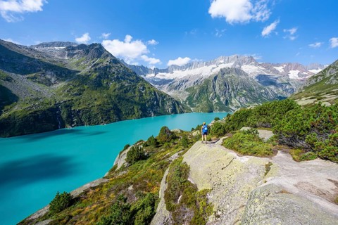 Female mountaineer in front of picturesque mountain landscape, turquoise-blue mountain lake