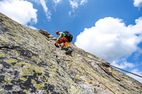 Mountaineers on steep rock face in the secured via ferrata Crocodile Mountain Lake at