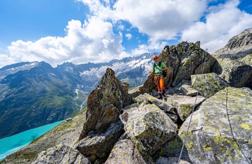Mountaineers between boulders on the secured via ferrata Crocodile Mountain Lake at