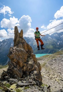 Crocodile rock formation, mountaineer on rope bridge in the Crocodile Mountain Lake via ferrata on