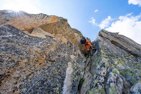 Mountaineers on steep rock face in the secured via ferrata Crocodile Mountain Lake at