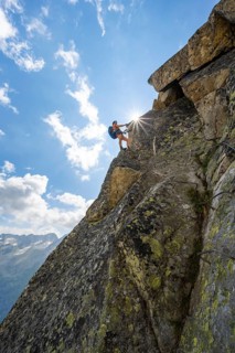 Female mountaineer on steep rock face on the secured via ferrata Krokodil-Bergsee am