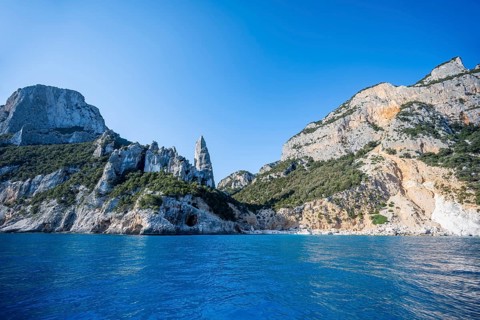 Picturesque rocky coast, cliffs with L'Aguglia pinnacle, blue sea and Cala GoloritzÃ© beach, Golfo
