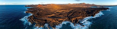 Coast with lava fields, volcanic landscape near Los Hervideros with red volcano MontaÃ±a Bermeja,