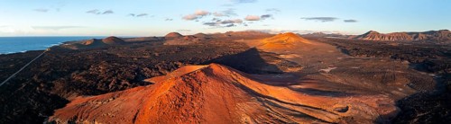 Picturesque volcanic landscape in evening light, red volcano MontaÃ±a Bermeja between lava fields,