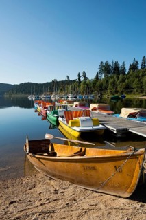 Morning atmosphere with colorful paddle boats and rowing boats, Schluchsee, Black Forest, Southern