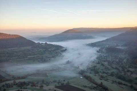 View of the foggy Neidlinger Valley in autumn at sunrise, Swabian Alb