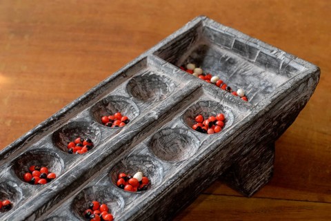 Traditional wooden game Pallankujhi, Pallamkuzhi, Pallangulli, Pallankulli or Alagulimane with red