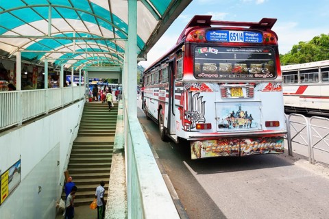 Fully decorated buses passing near an underground passage, Kandy, Sri Lanka